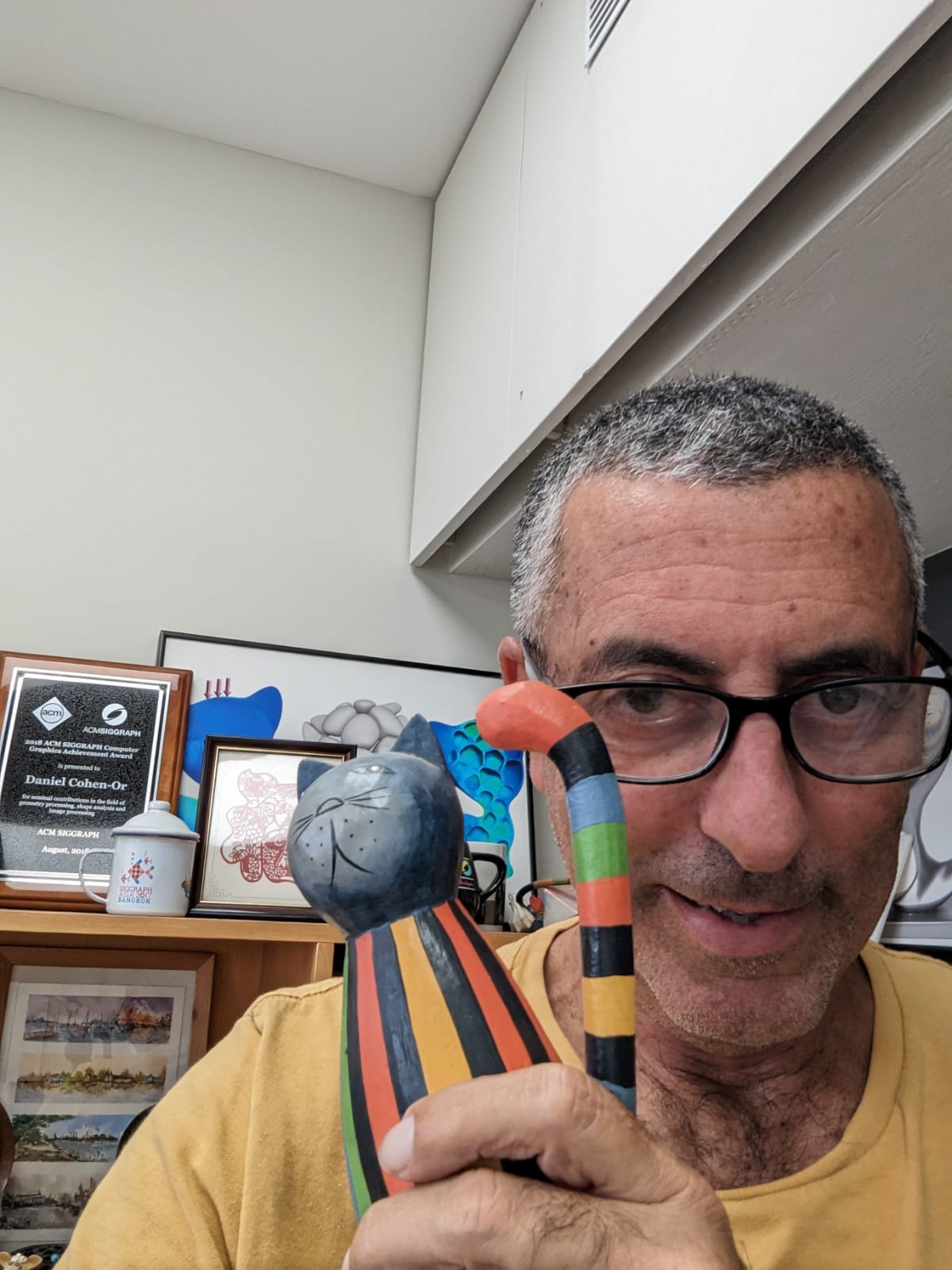Daniel Cohen-Or holding a colorful cat sculpture